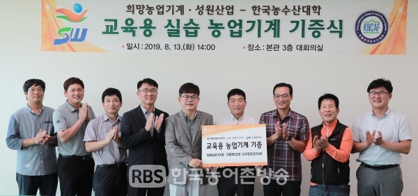한국농수산대학 농기계 기증 행사에서 관계자들이 기념 촬영을 하고 있다.