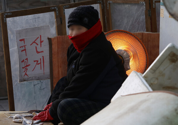 전국 대부분 지역 기온이 영하권으로 떨어진 30일 오전 서울 중구 중림시장에서 상인이 난로에 의지해 아침 시장을 준비하고 있다. 2022.11.30 [뉴스1]