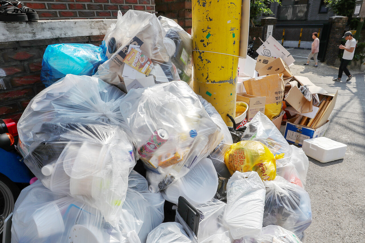 재활용 쓰레기들이 분리되지 않은 채 한 봉투에 담겨 버려진 서울의 한 주택가 [뉴스1]