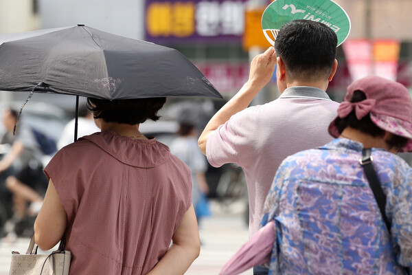 폭염이 일주일 넘게 이어진 4일 오후 대구 수성구 달구벌대로에서 시민들이 양산과 부채로 뙤약볕을 가리고 있다. [사진=뉴스1] 