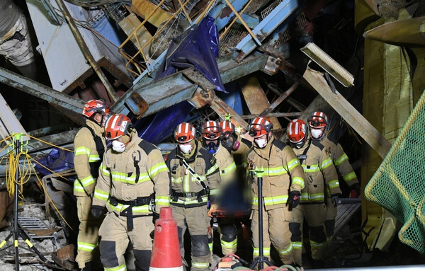 12일 오전울산화력발전소 붕괴 현장에서 수습된 매몰자를 구조대원들이 들것을 이용해 붕괴된 건물 밖으로 나오고 있다. [사진=뉴스1]